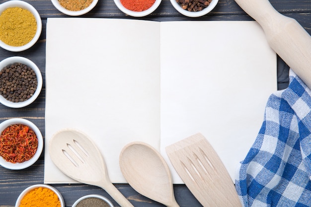 Various spices selection and notepad for copy space on wooden table