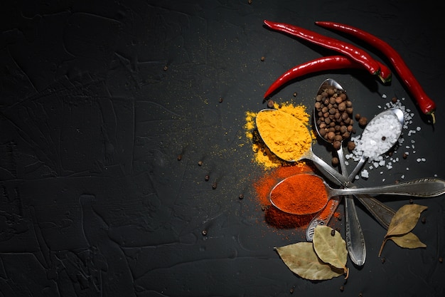 Various spices spoons on stone table