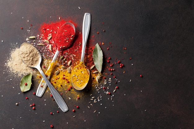 Various spices spoons on stone table