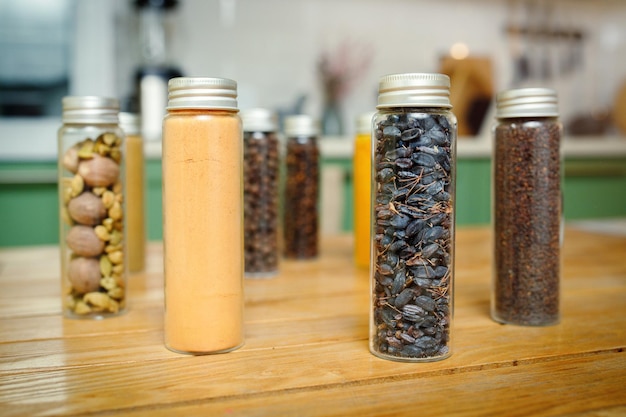 Various spices in transparent jars on a home kitchen table