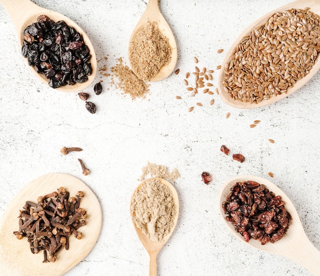 Photo various spoons with arrangement of seeds top view