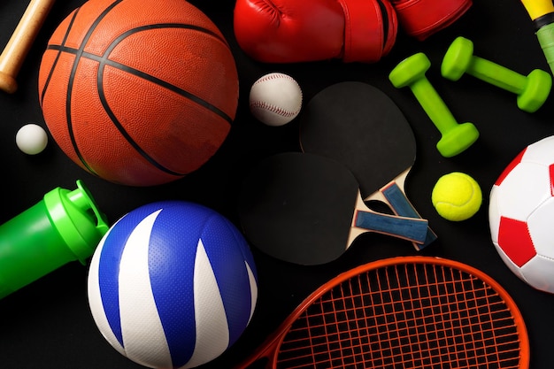 Various sports equipment on black background studio shot