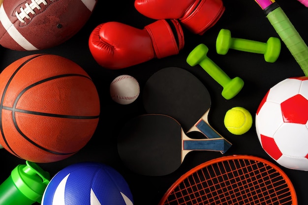 Various sports equipment on black background studio shot