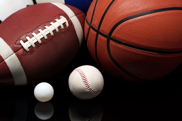 Various sports equipment on black background studio shot