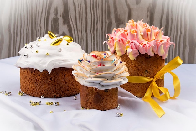 Various Spring Easter cakes with white icing and sugar decor on the table decorated in rustic style