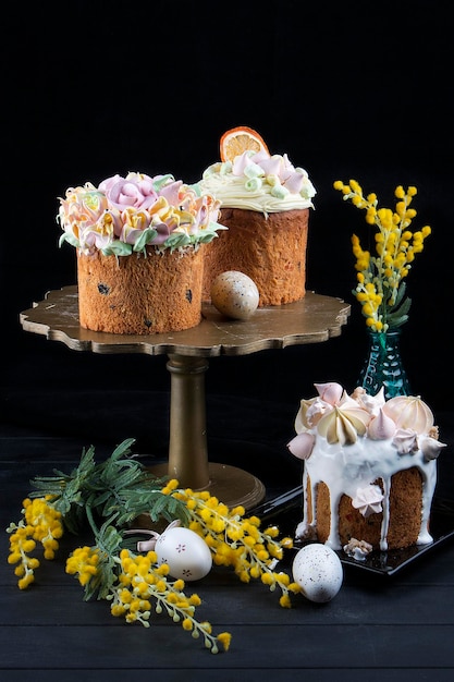 Various Spring Easter cakes with white icing and sugar decor on the table decorated in rustic style