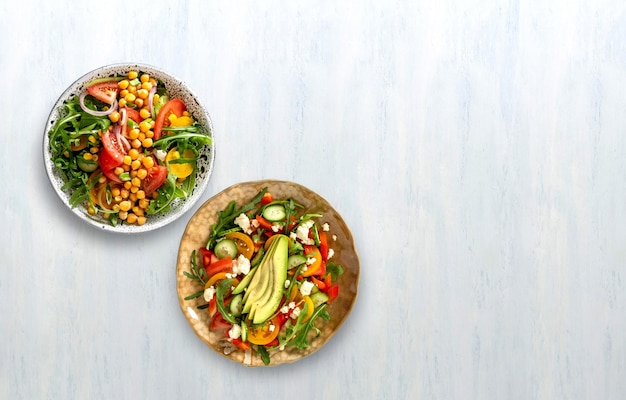 Foto varie insalate di verdure sane estive con avocado, cetriolo, ravanello, peperone e pomodoro cibo sanovista dall'alto