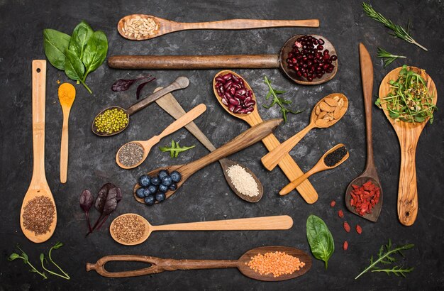 Various superfoods set in wooden spoons diet organic products clean eating concept