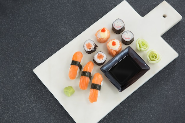 Various sushi on tray with sauce