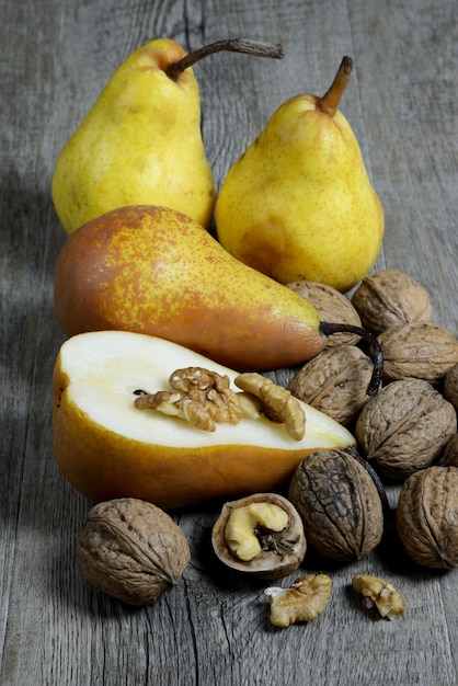 various sweet pears on old wooden table and walnut