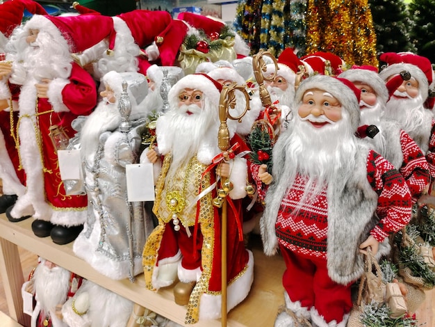 Various toy Santa Clauses are on the store shelf for sale