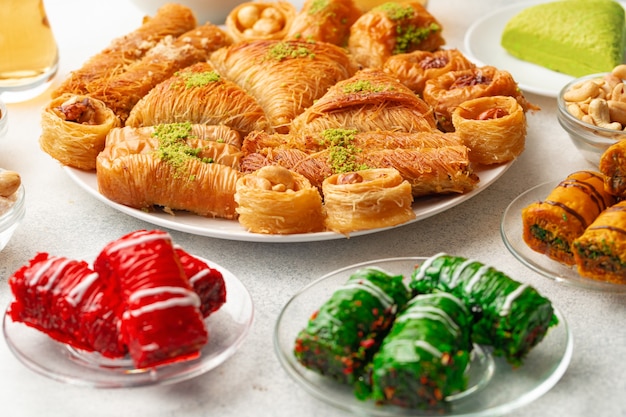 Various turkish sweets and cup of tea on white textured background