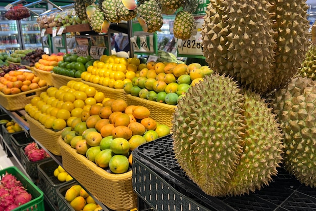 Various type of fresh fruits arrange neatly in grocery store Durian mango lemon on rack