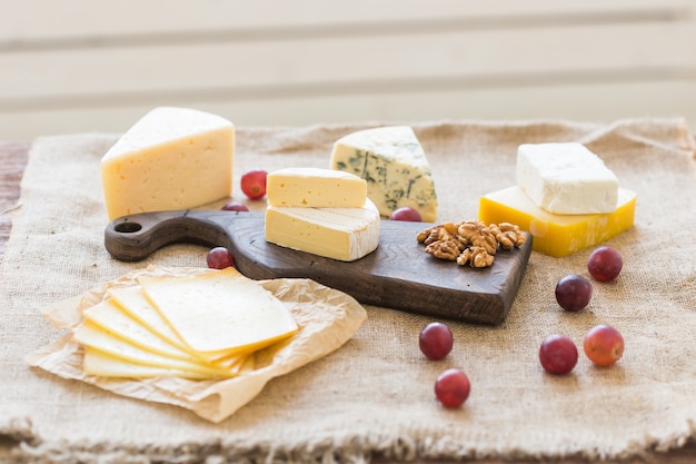 Various types of cheese, blue cheese and brie with grapes and nuts.