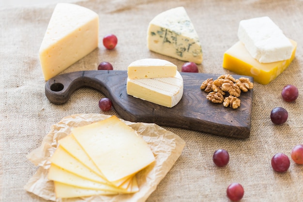 Various types of cheese, blue cheese and brie with grapes and nuts.