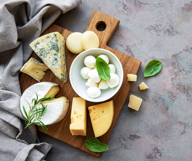 Vari tipi di formaggio su una scrivania in cemento