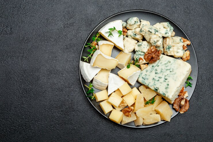 Various types of cheese in dark plate