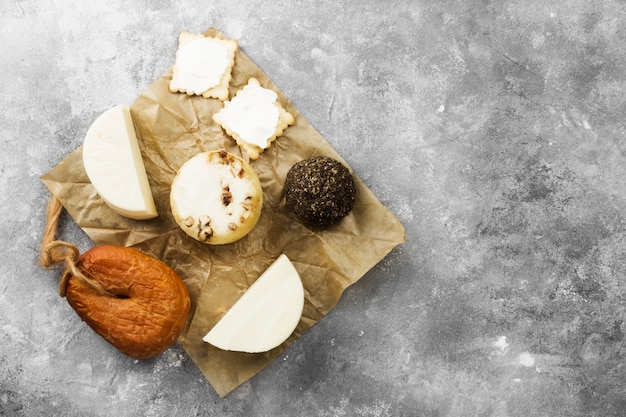 Various types of cheese on a gray background. Top view, copy space.