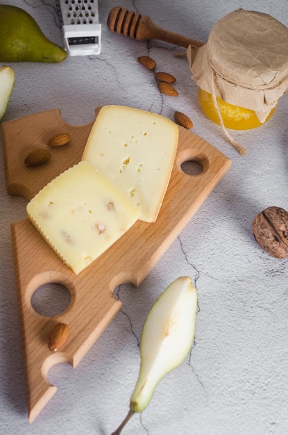 Various types of cheese heads and pieces on a wooden board