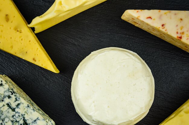 Various types of cheese on a slate board. Top view