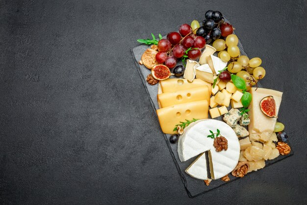 Various types of cheese on stone serving board