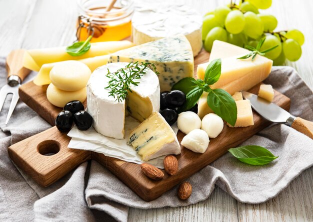 Foto diversi tipi di formaggio su uno sfondo bianco di legno