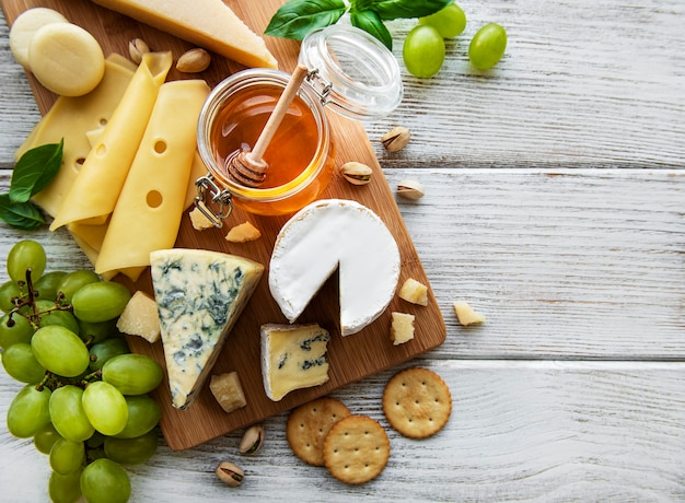 Various types of cheese on a white wooden surface