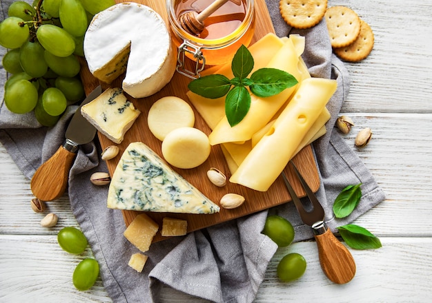 Various types of cheese  on a white wooden  surface