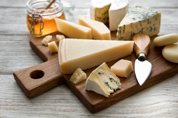 Various types of cheese  on a white wooden  table