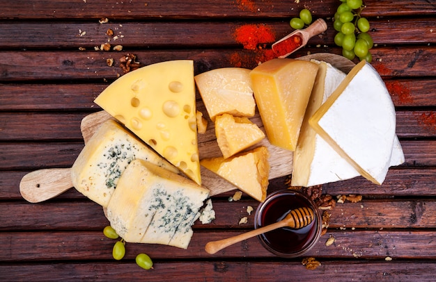 Various types of cheese with honey, nuts and spices