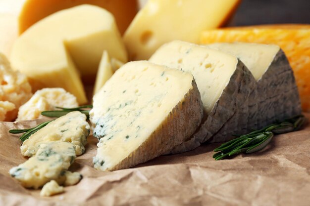 various types of cheese with rosemary on table close up