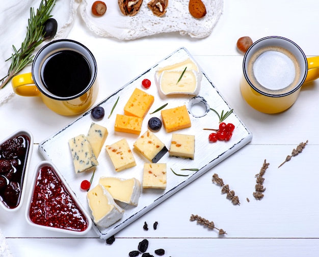 타르타르 및 정향 잼 및 블랙 커피가 포함 된 다양한 종류의 치즈