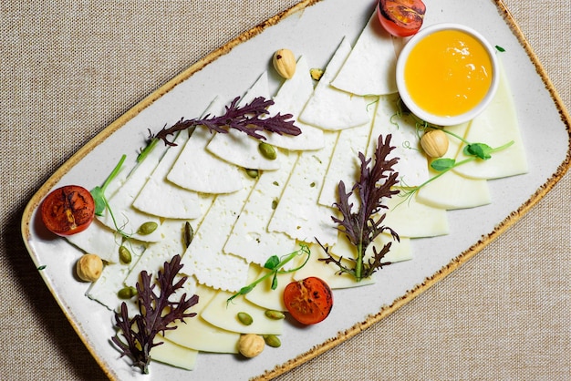 プレート上のトマトルッコラナッツとさまざまな種類のチーズレストランメニュー上面図