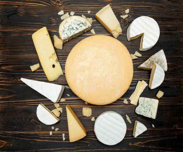 Photo various types of cheese on a wooden table