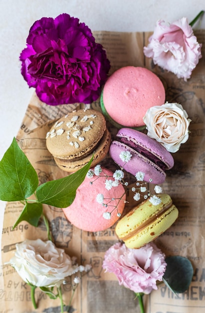 Various types of colorful macarons or macaroons decorated with flowers Traditional french dessert