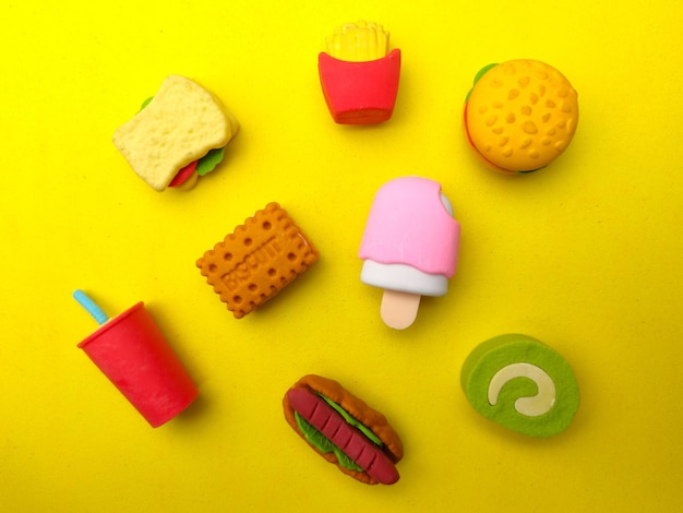 Various types of colourful food toys on a yellow background