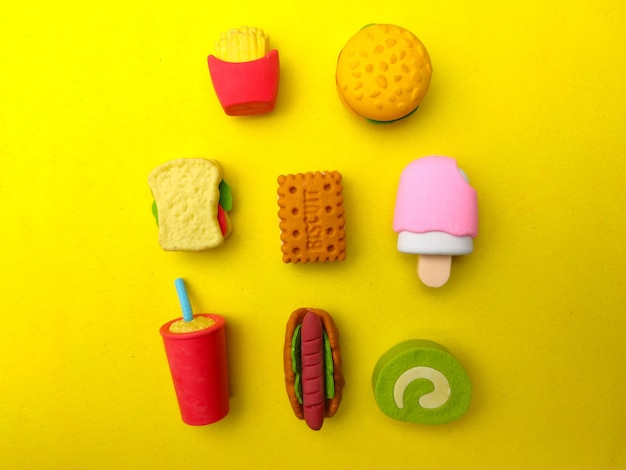 Various types of colourful food toys on a yellow background