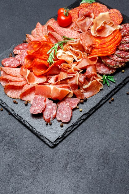 Various types of Dried organic salami sausage and parma on concrete surface