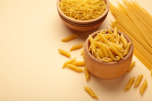 Various types of Italian pasta on beige background