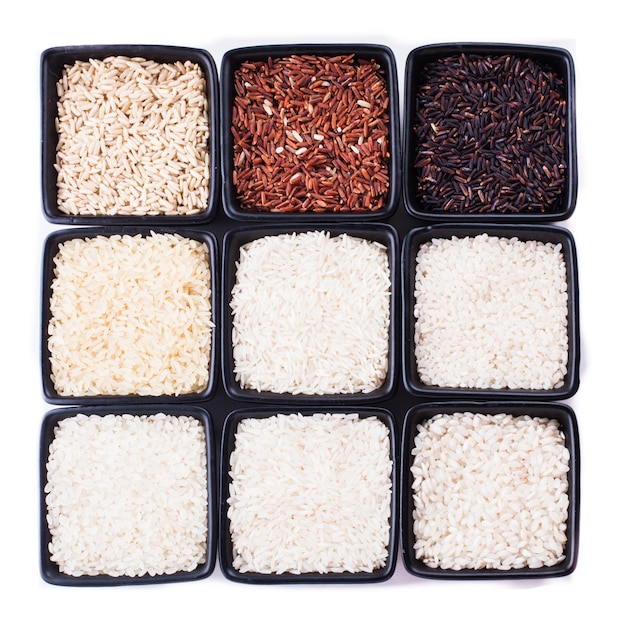 白で隔離される黒いボウルのさまざまな種類の米