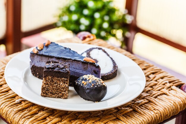 Various vegan desserts on a plate, outside in a cafe