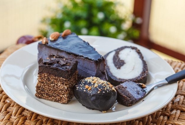 Various vegan desserts on a plate, outside in a cafe 