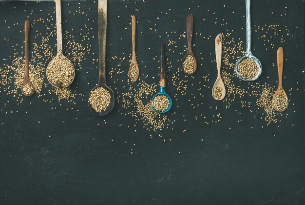 Various vintage kitchen spoons and green buckwheat grains