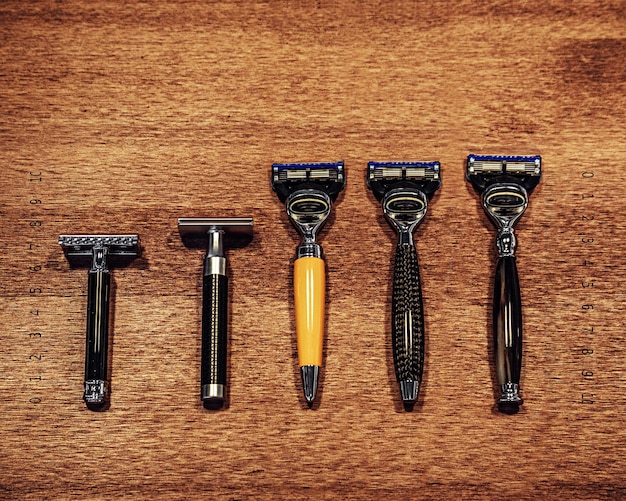 Various vintage razors shaving machines on a wooden and fabric background