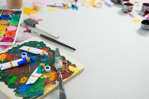 Various watercolor tubes and palette knife on white background