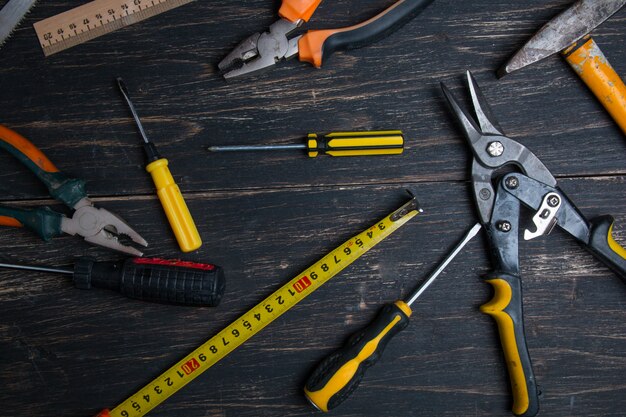 Various working tool on a dark wooden table.