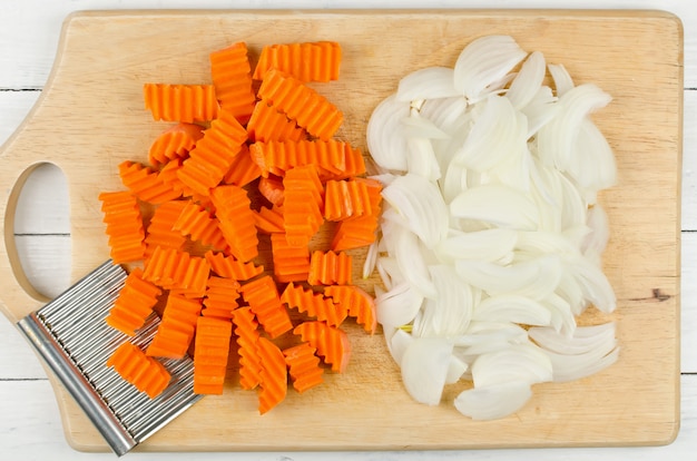 Photo variously sliced for cooking carrots and onions on a cutting board