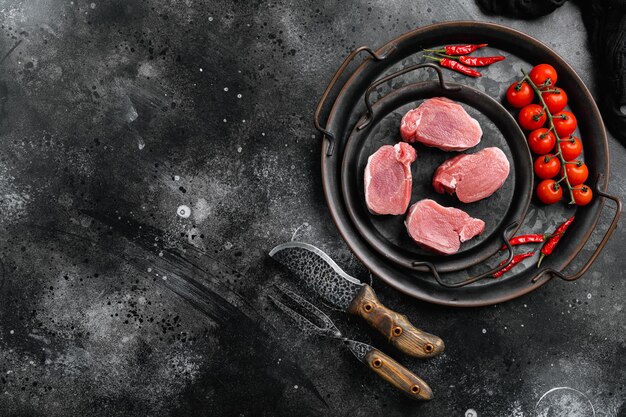 Varkenshaas Vers rauw vlees bereid om te koken ingesteld op zwarte donkere stenen tafel achtergrond bovenaanzicht plat lag met kopieerruimte voor tekst