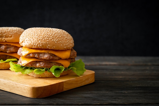 Varkenshamburgers met kaas op een houten bord