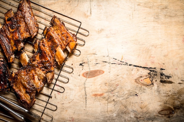 Varkensribbetjes gegrild op de grill. Op houten tafel.